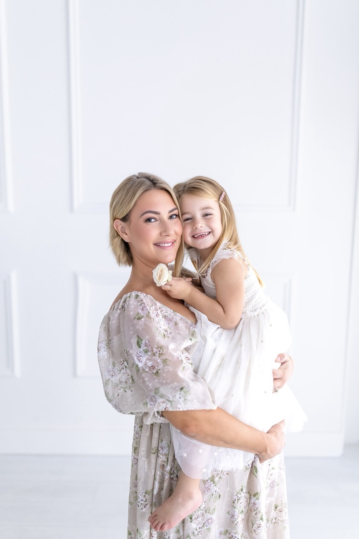 Creator holding her daughter, both smiling